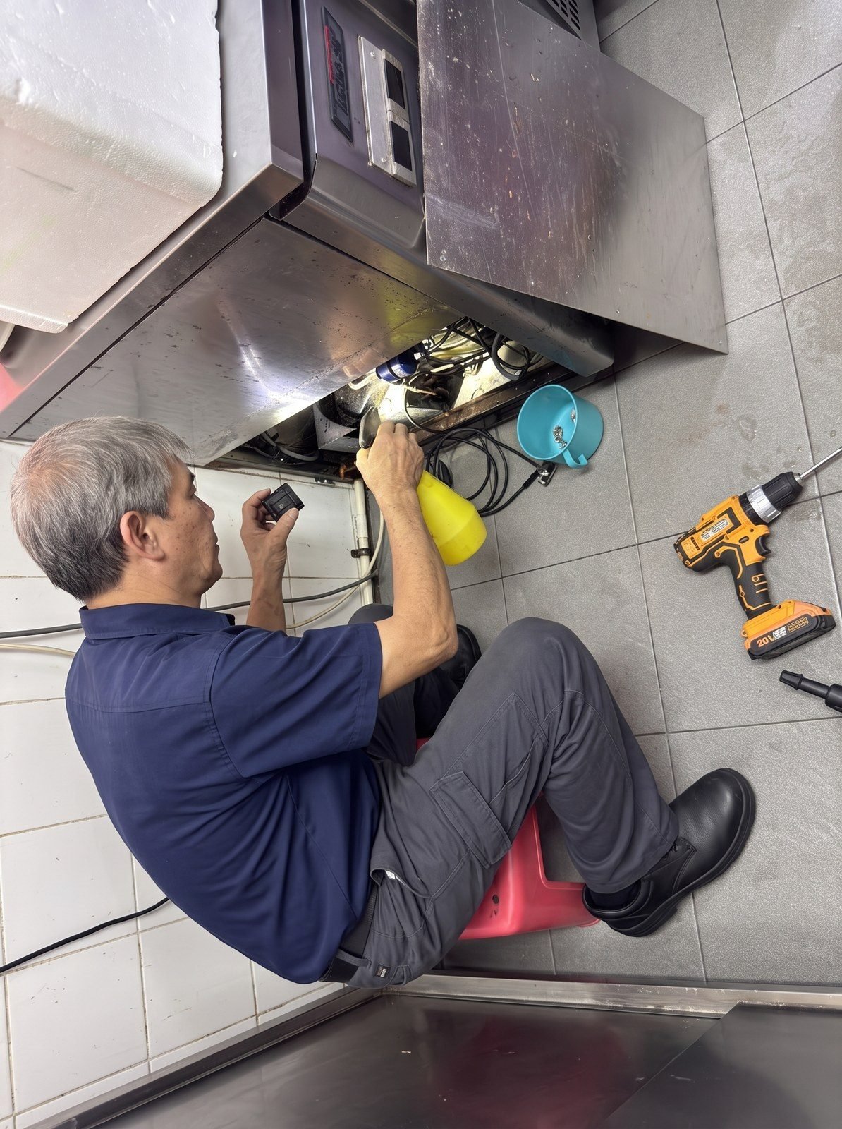 Alan servicing a commercial counter chiller in a Singapore kitchen