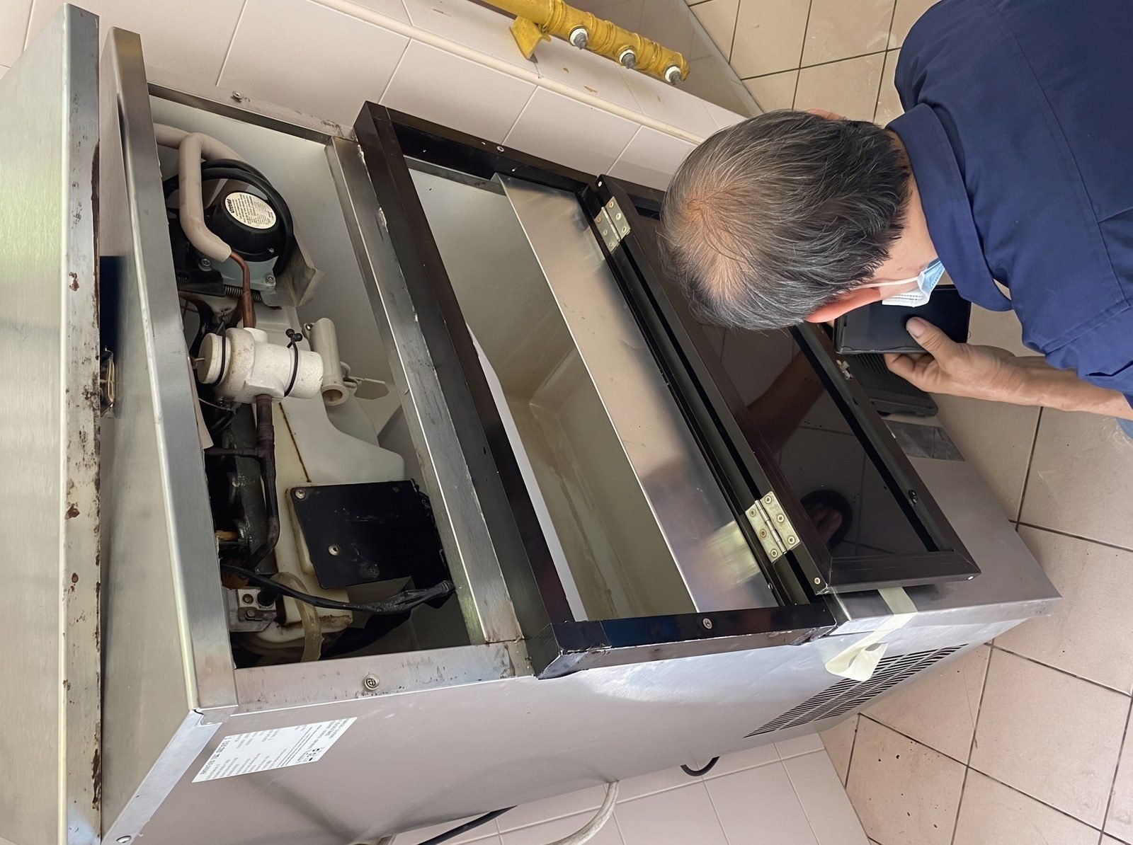 Alan inspecting a commercial freezer on site
